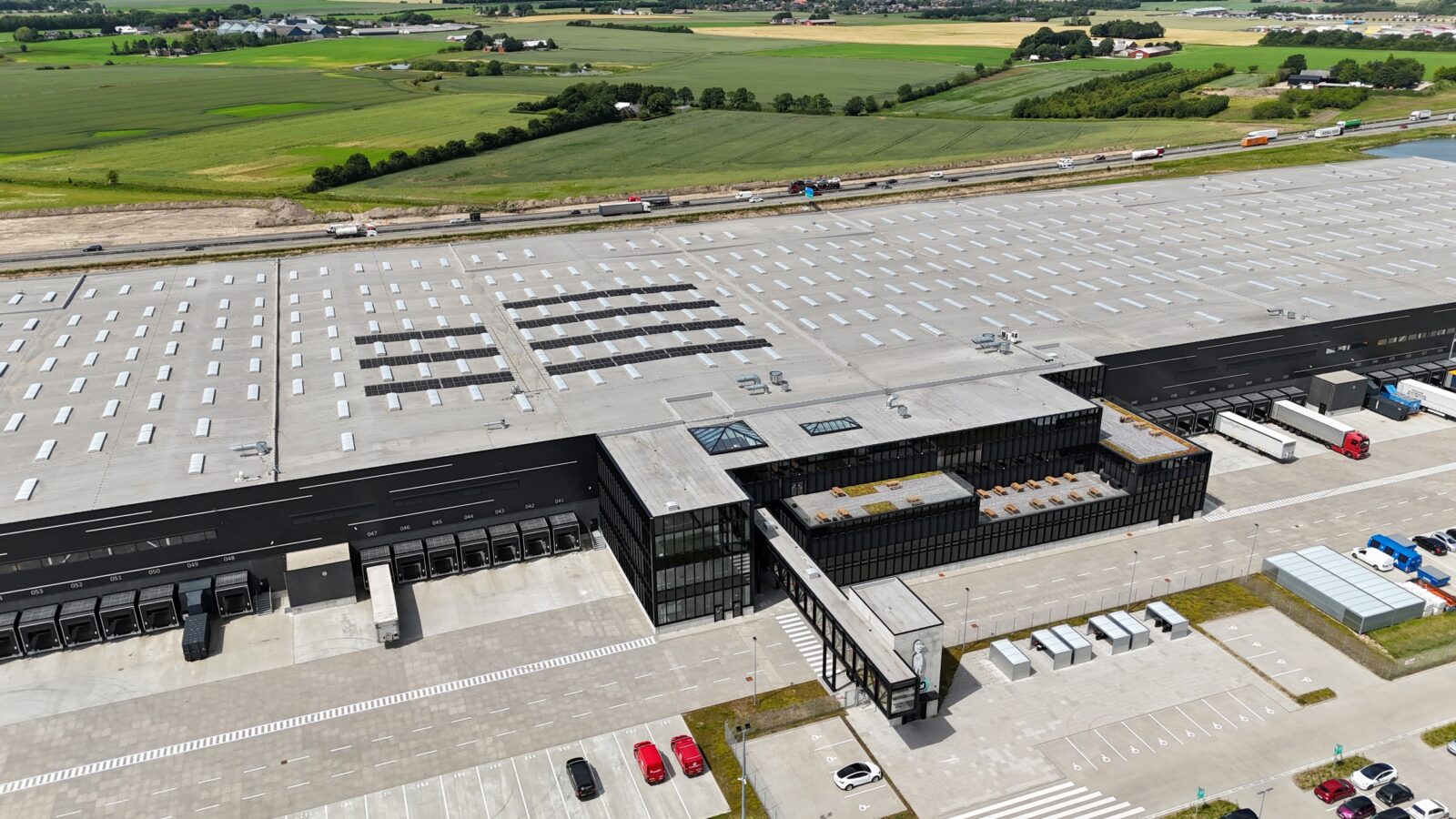 500 meter Fjelsø facade på Normal Logistikpark i Hedensted med ståldøre, aluvinduer og facadebeklædning.